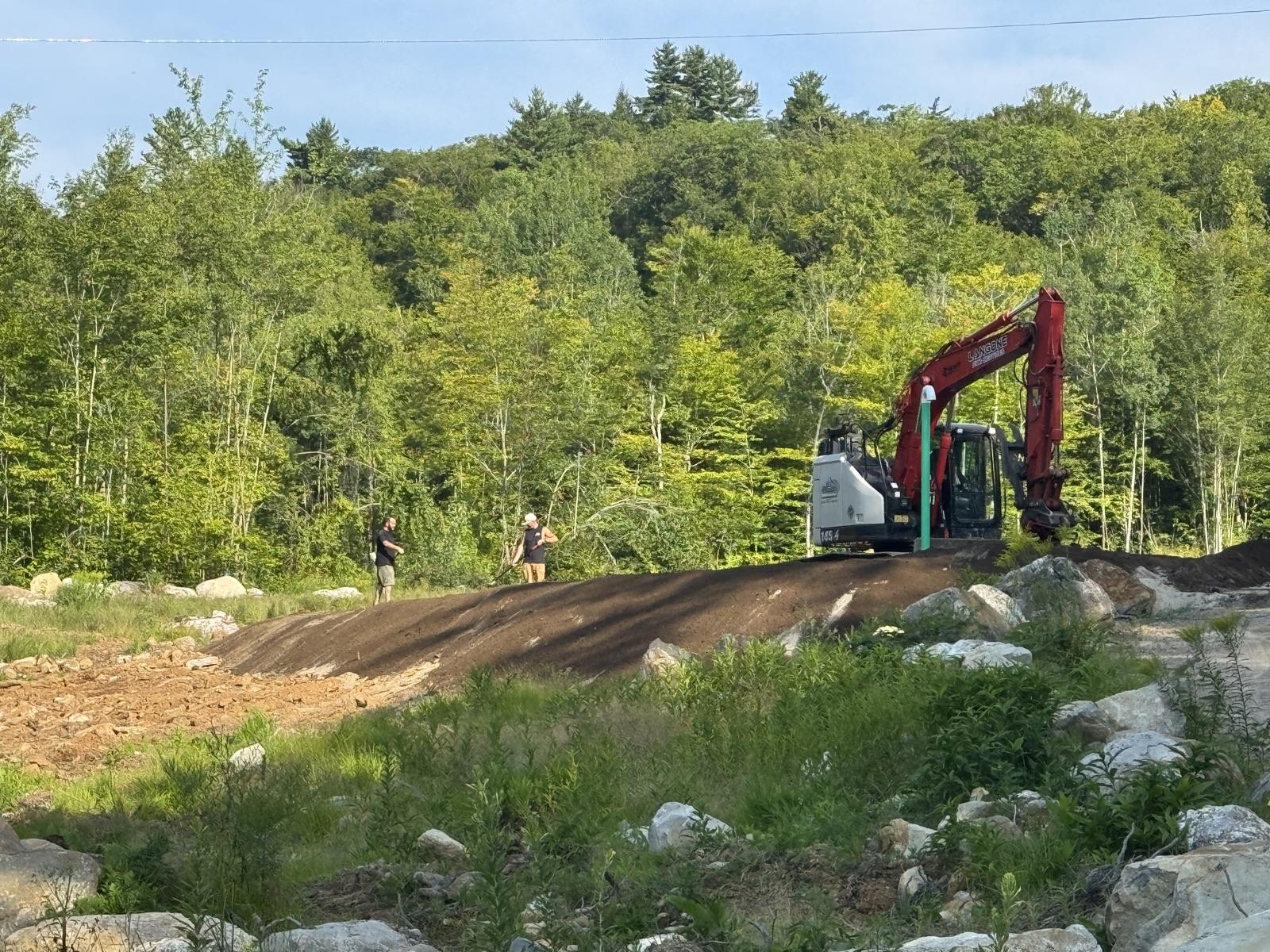Langone Site Services lettering on the excavator boom